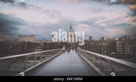 Dramatischer Sonnenuntergang über der St. Paul`s Kathedrale mit Blick auf die Millennium Bridge in London Stockfoto